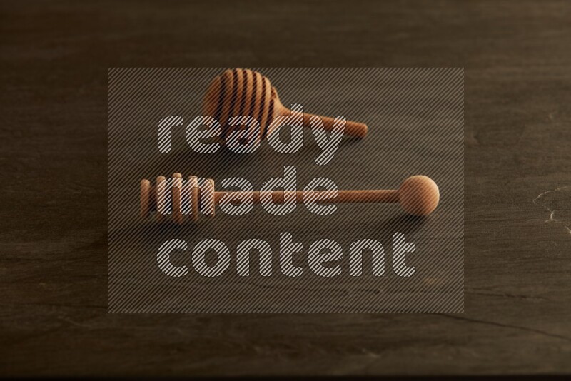 Wooden honey dipper on black slate background