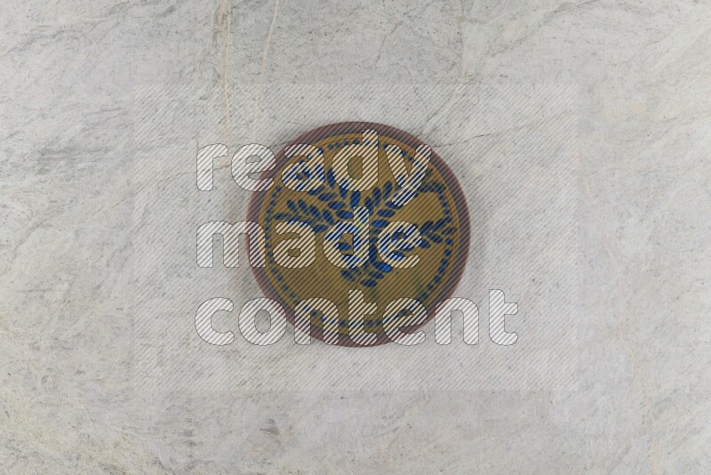 A decorative pottery plate on grey marble background