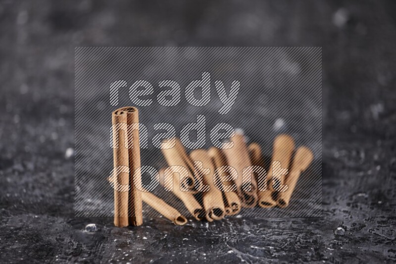 Cinnamon sticks on a textured black background