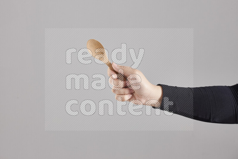 A woman in black abaya holding different wooden essentials in different positions
