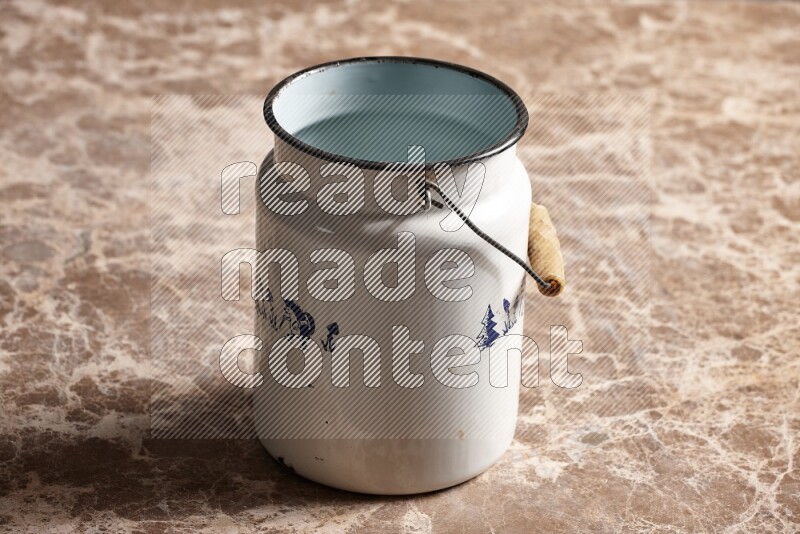 A vintage milk can on beige marble background