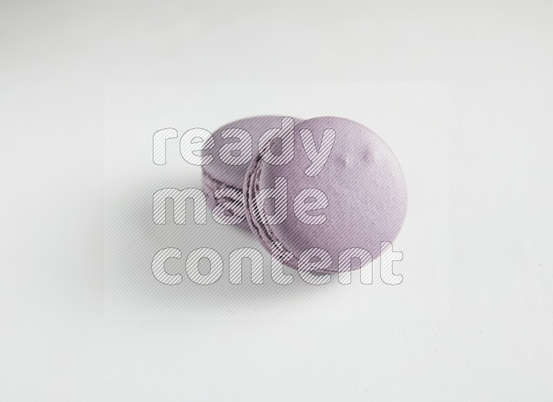 45º Shot of two Purple Blueberry macarons on white background