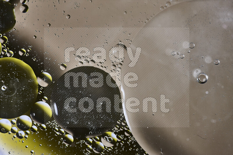 Close-ups of abstract oil bubbles on water surface in shades of brown, black and yellow