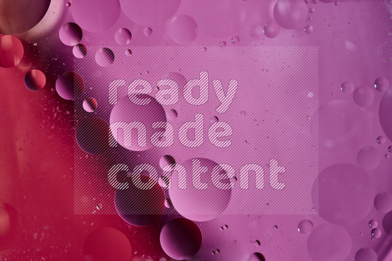 Close-ups of abstract oil bubbles on water surface in shades of red and pink