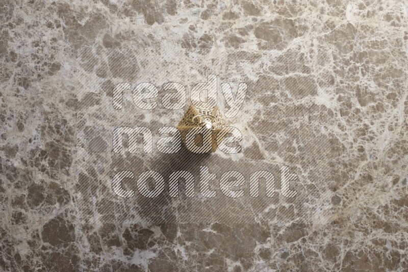 A lantern placed on a beige marble background