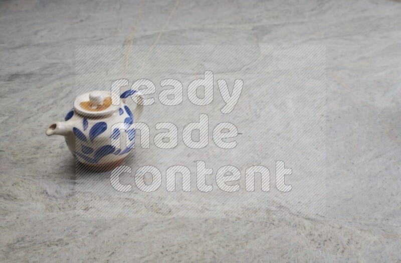 A pottery teapot on grey marble background