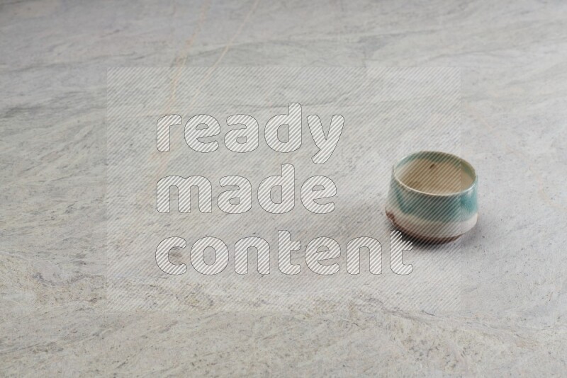 A multicolored pottery bowl on grey marble background