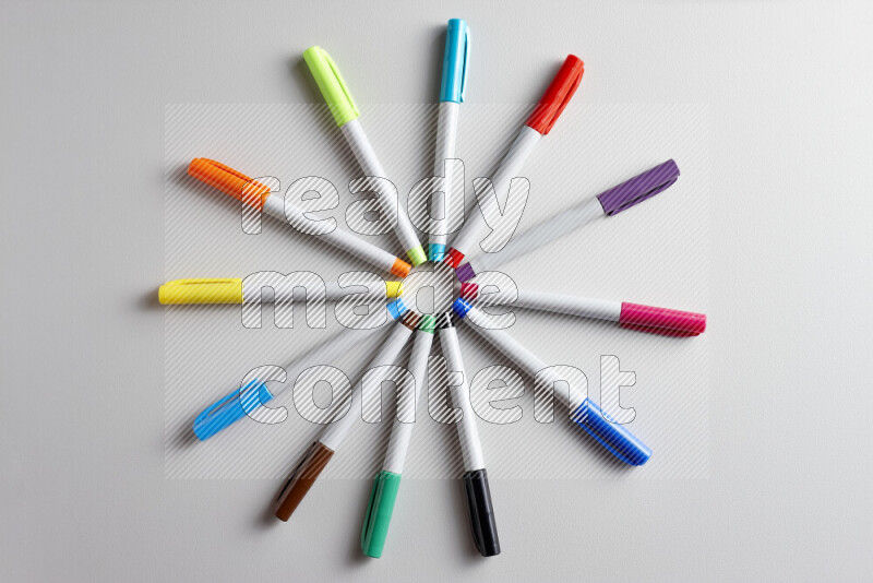 An arrangement of coloring pens in different colors on grey background