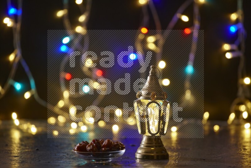 A traditional ramadan lantern surrounded by glowing fairy lights in a dark setup
