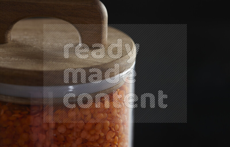 Lentils in a glass jar on black background