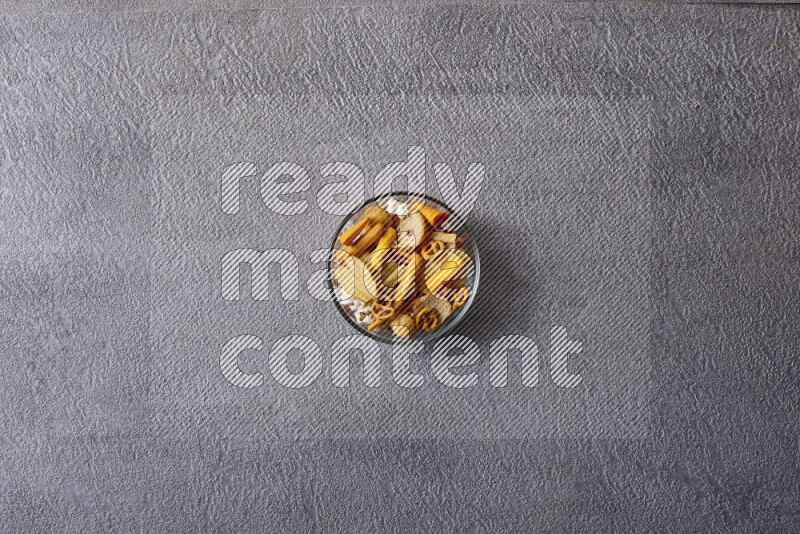 Assorted snacks in pottery bowls on grey background