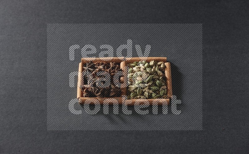 2 squares of cinnamon sticks full of cardamom and star anise on black flooring