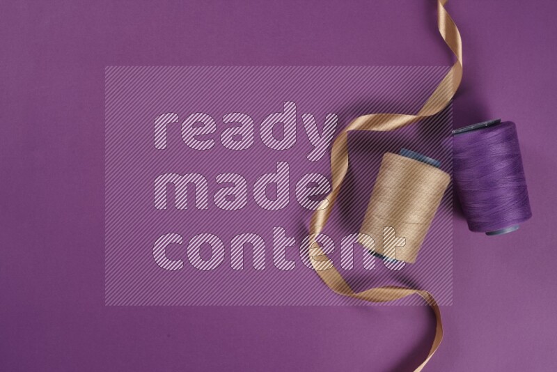 A beige collection of sewing and tailoring tools arranged on a purple background