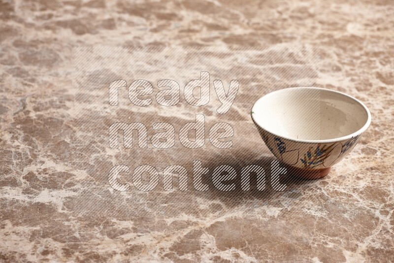 A decorative pottery bowl on beige marble background