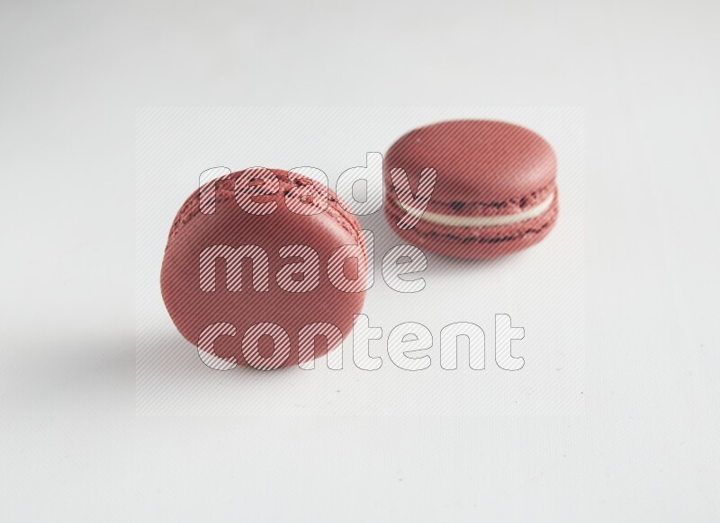 45º Shot of two Red Velvet macarons on white background