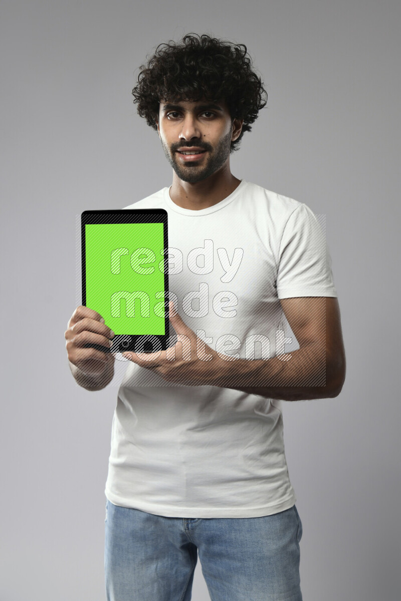 A man wearing casual standing and showing a tablet screen on white background
