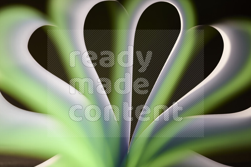 An abstract art piece displaying smooth curves in white and green gradients created by colored light