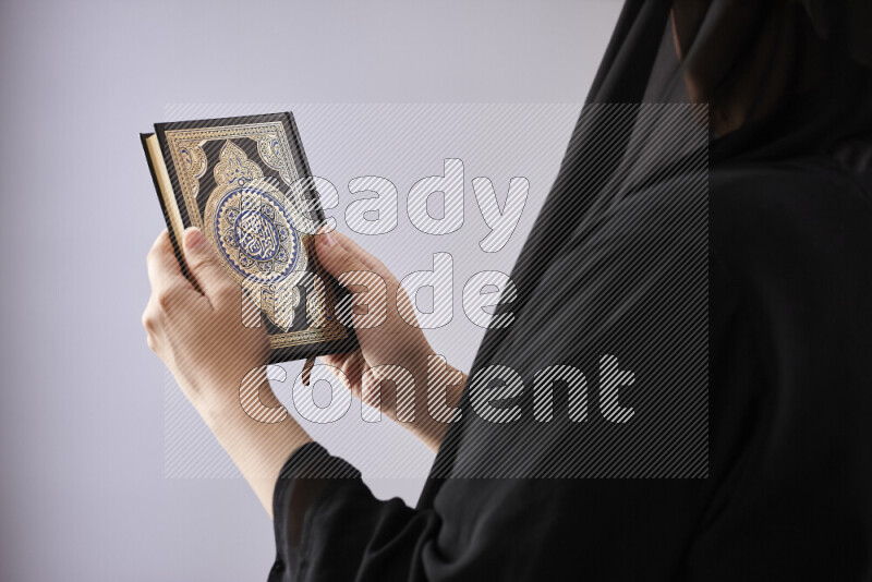 A woman hands holding moshaf in different positions