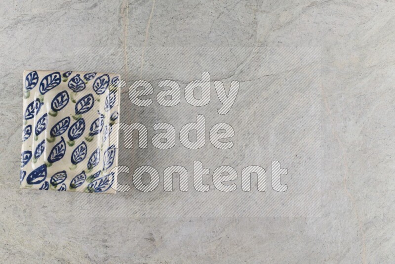 A decorative pottery plate on grey marble background