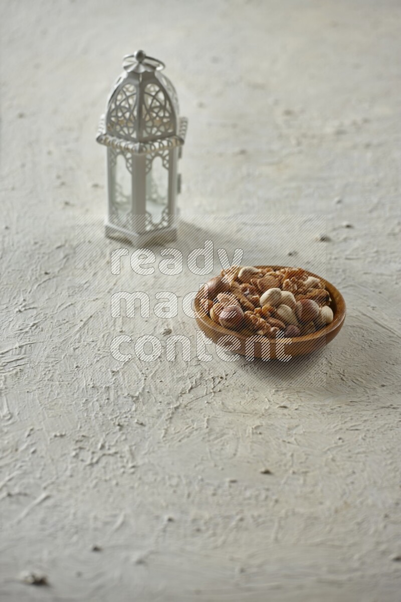 A white lantern with different drinks, dates, nuts, prayer beads and quran on white background