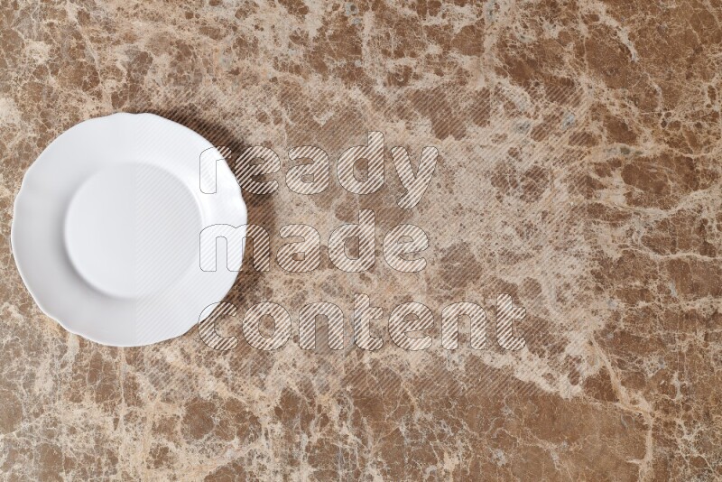 Top View Shot Of A White Ceramic Circular Plate On beige Marble Flooring