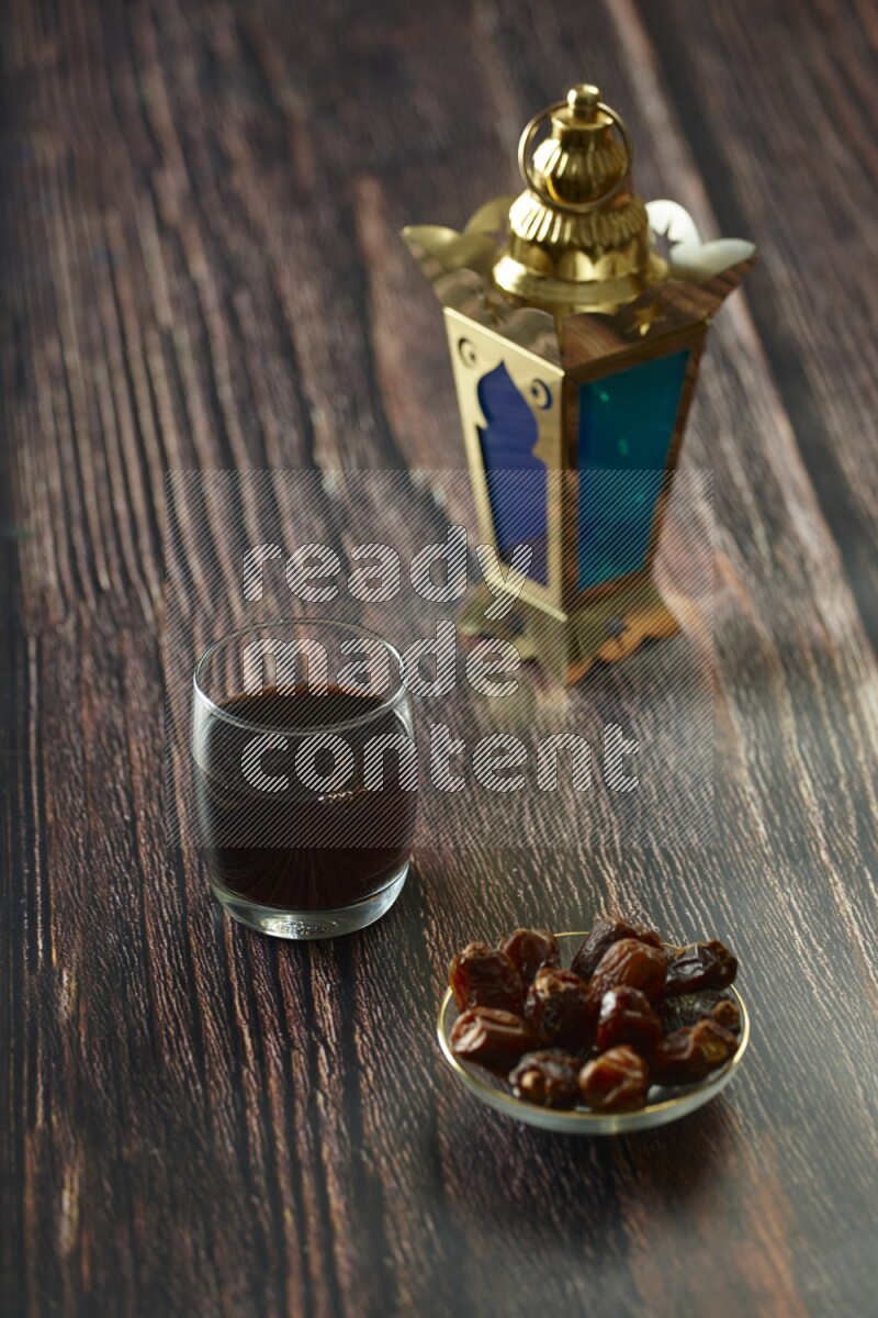 A golden lantern with different drinks, dates, nuts, prayer beads and quran on brown wooden background