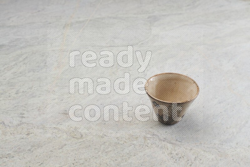 A multicolored pottery Cup on grey marble background