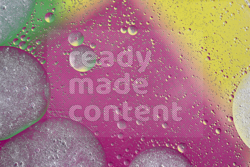 Close-ups of abstract oil bubbles on water surface in shades of yellow, green and pink