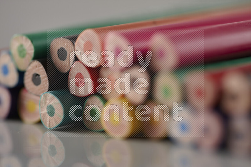 An array of colored pencils on grey background