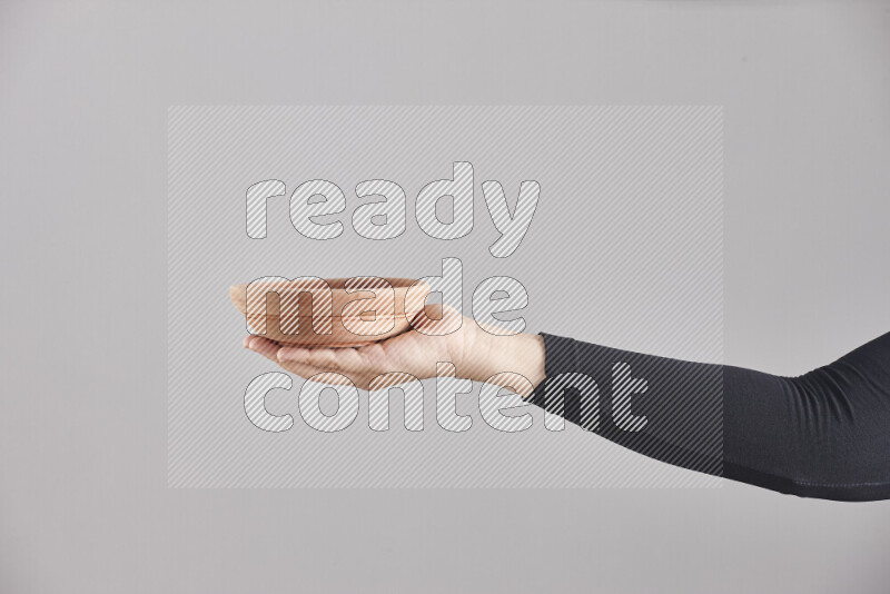 A woman in black abaya holding different wooden essentials in different positions