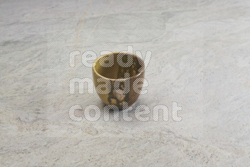 A multicolored pottery Cup on grey marble background