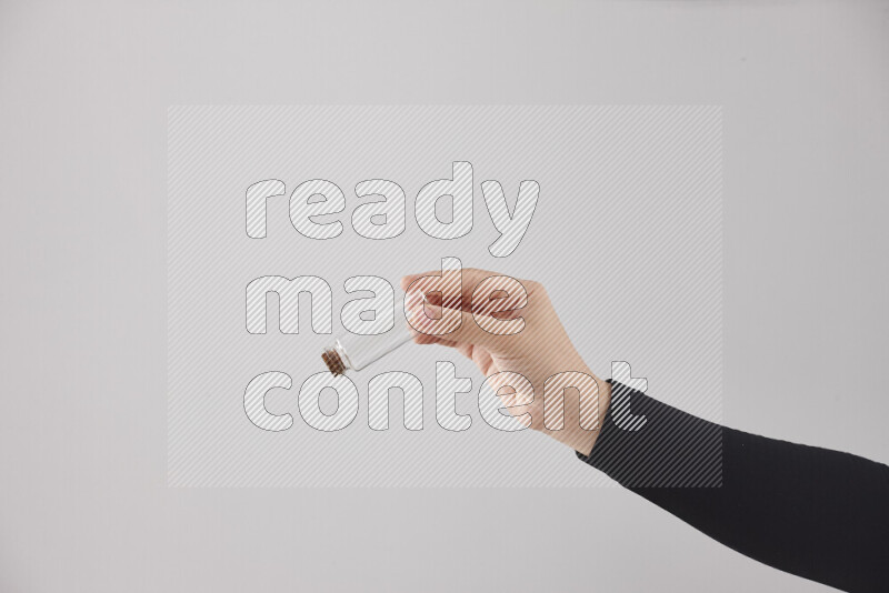 A woman in black abaya holding different glassware in different positions