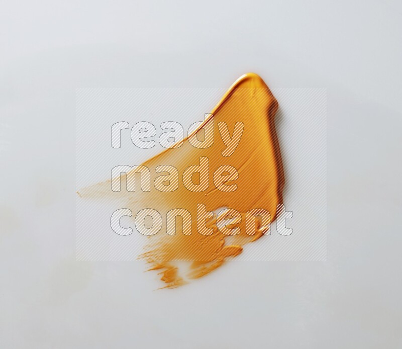 An orange single curved painting knife stroke on white background