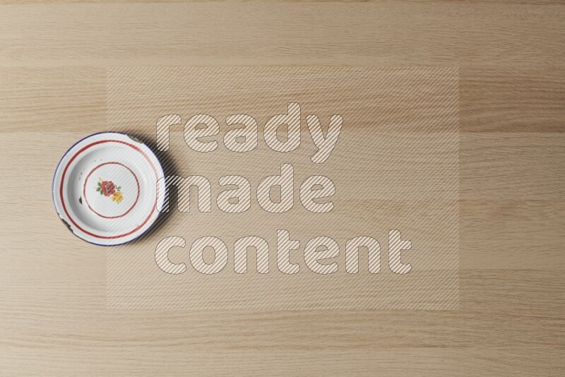 صحن معدني عتيق على خلفية خشبية فاتحة