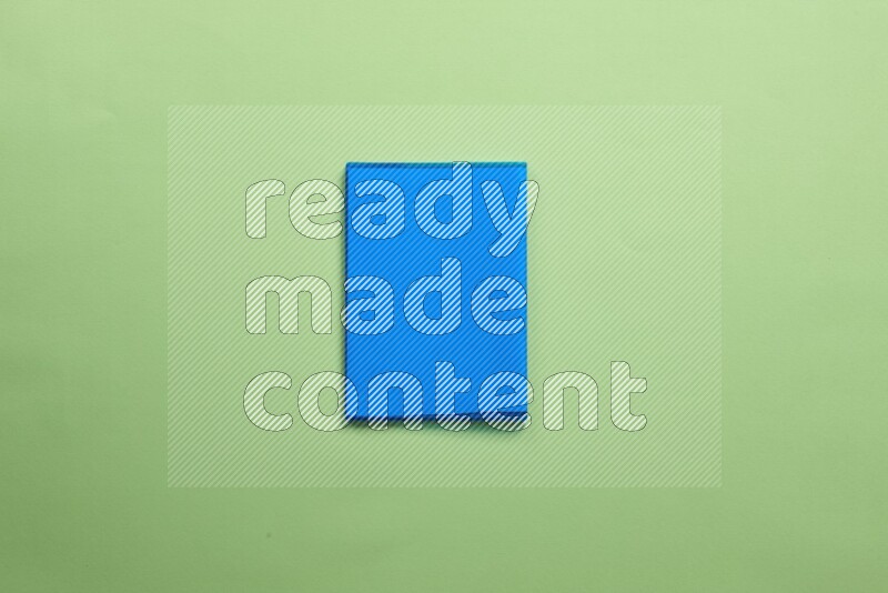 Multicolored notebooks on green background