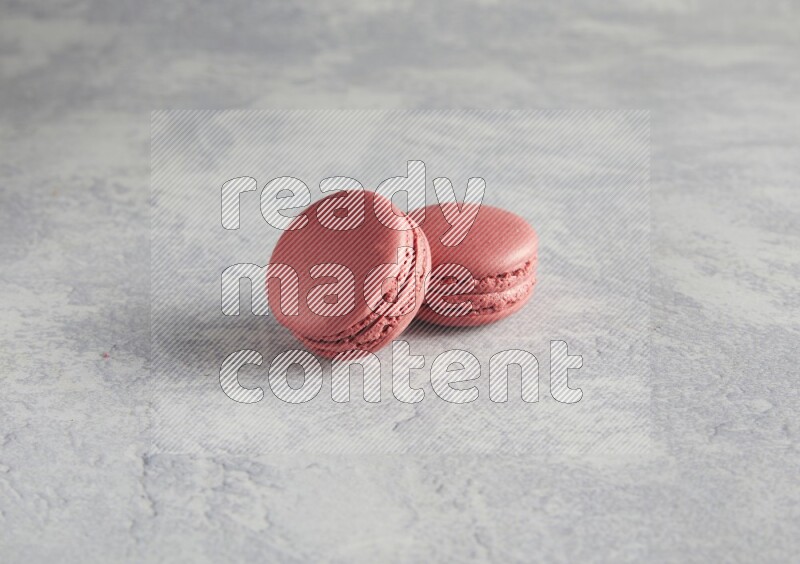 45º Shot of two Pink Raspberry macarons  on white  marble background