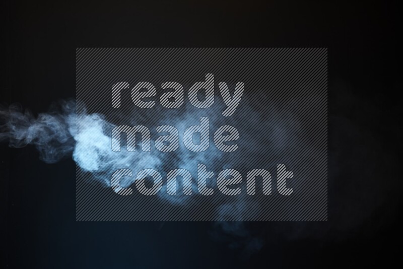 Heavy smoke in blue isolated on black background
