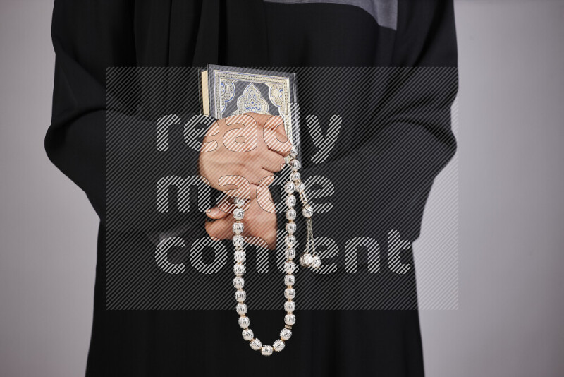 A woman hands holding moshaf in different positions