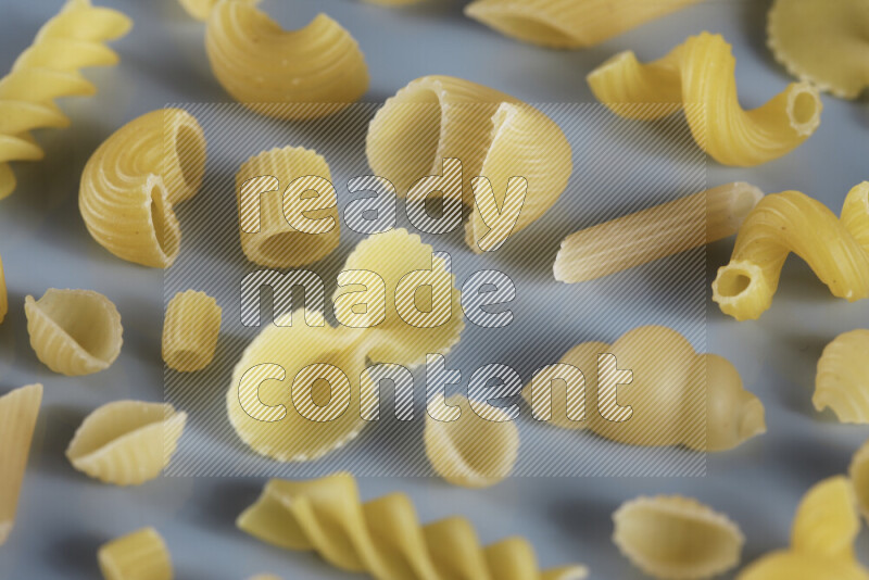 Different pasta types on light blue background
