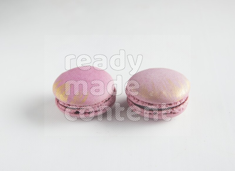 45º Shot of two Purple Strawberry macarons on white background