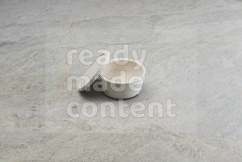 A white pottery bowl on grey marble background