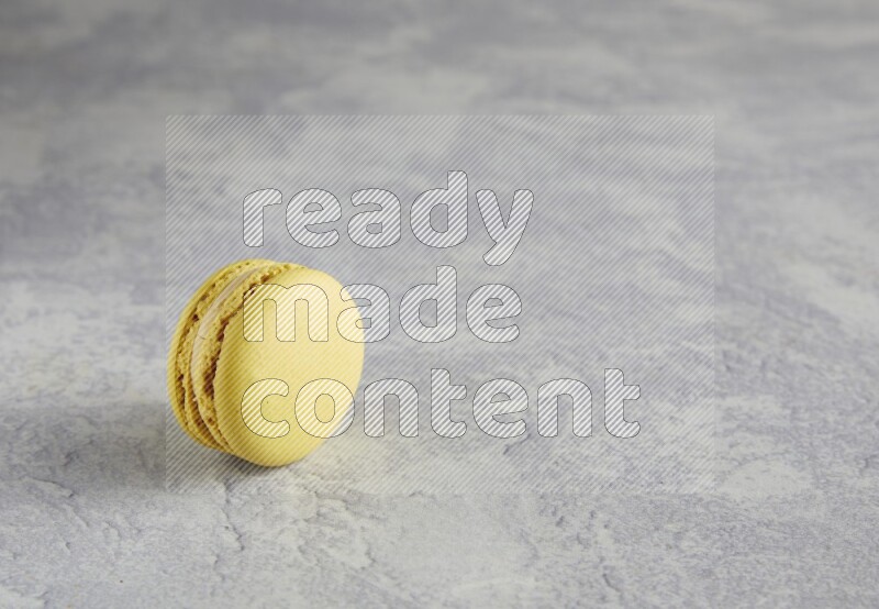 45º Shot of Yellow Lime macaron on white marble
