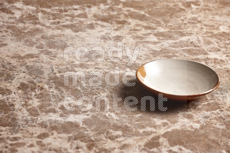 A multicolored pottery plate on beige marble background