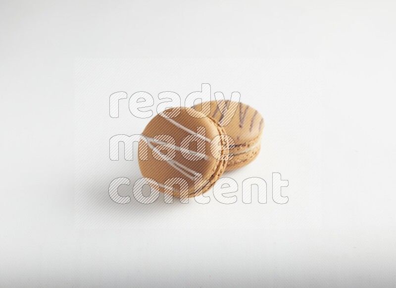 45º Shot of of two assorted Brown Irish Cream, and light brown  Almond Cream macarons on white background