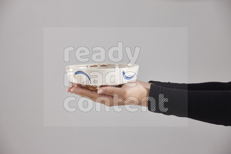 A woman in black abaya holding different pottery essentials in different positions