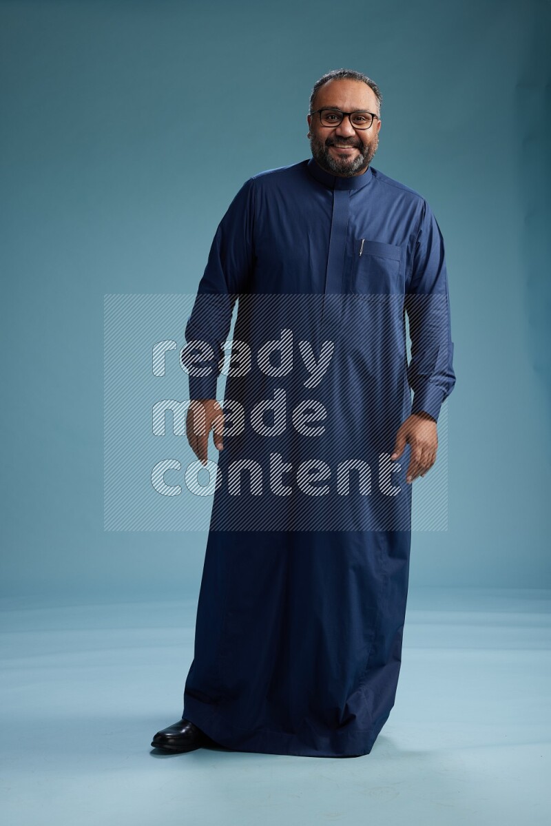 Saudi Man without shimag Standing Interacting with the camera on blue background