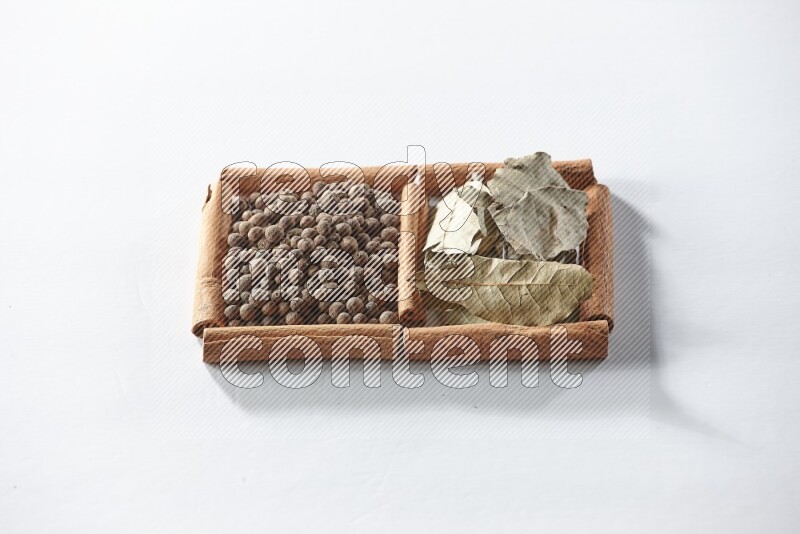 2 squares of cinnamon sticks full of allspice and bay laurel leaves on white flooring