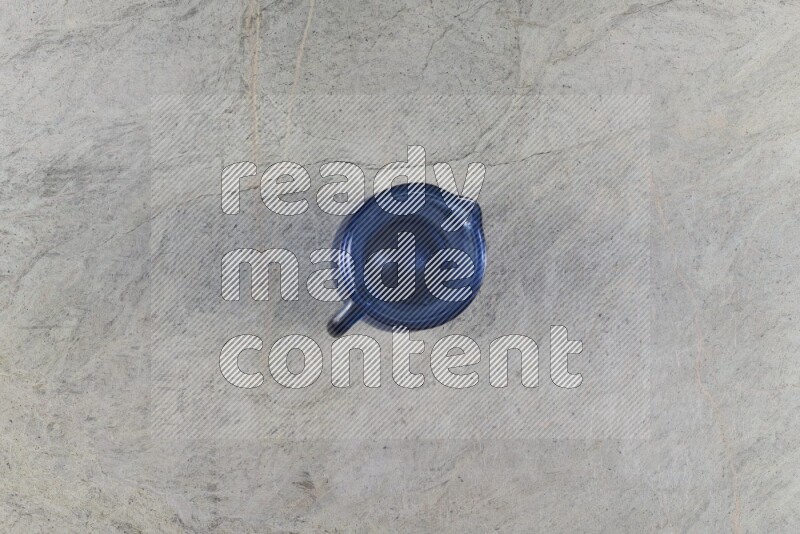 A colored glass jug on grey marble background