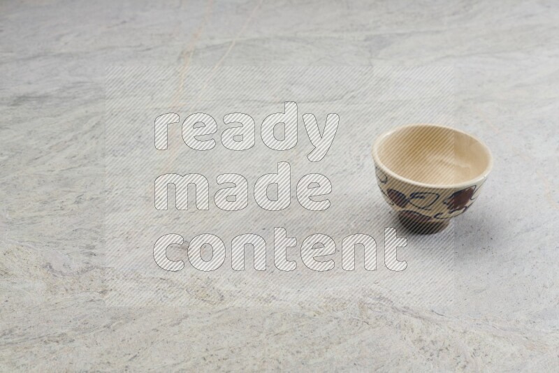 A multicolored pottery bowl on grey marble background