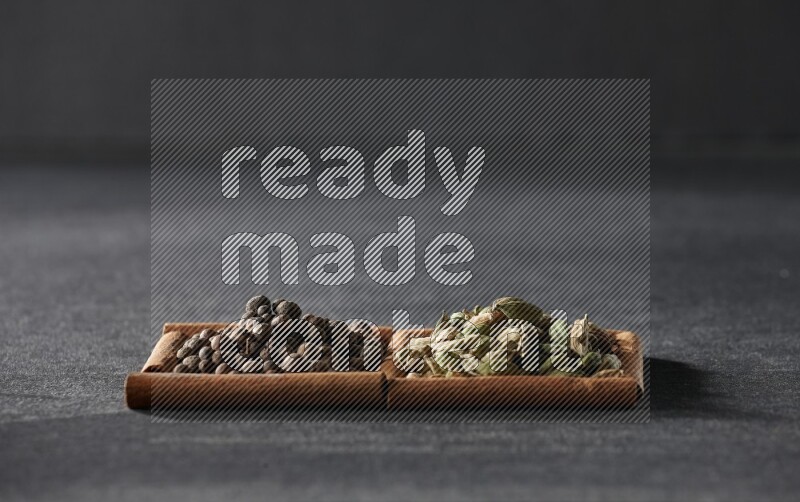 2 squares of cinnamon sticks full of allspice and cardamom on black flooring